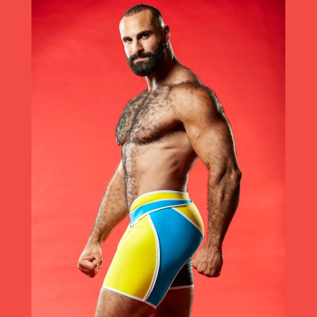 Unieke gele short met hoge tailleband en zwarte, blauwe en witte accenten, ontworpen door het Italiaanse modehuis Sparta’s Harness perfect voor gay mannen en te koop bij Flavourez.