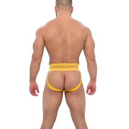 Gele jockstrap met Griekse details. Geïnspireerd op de jaren 70 en ontworpen door Sparta's Harness voor gay en queer mannen. Te koop bij Flavourez.