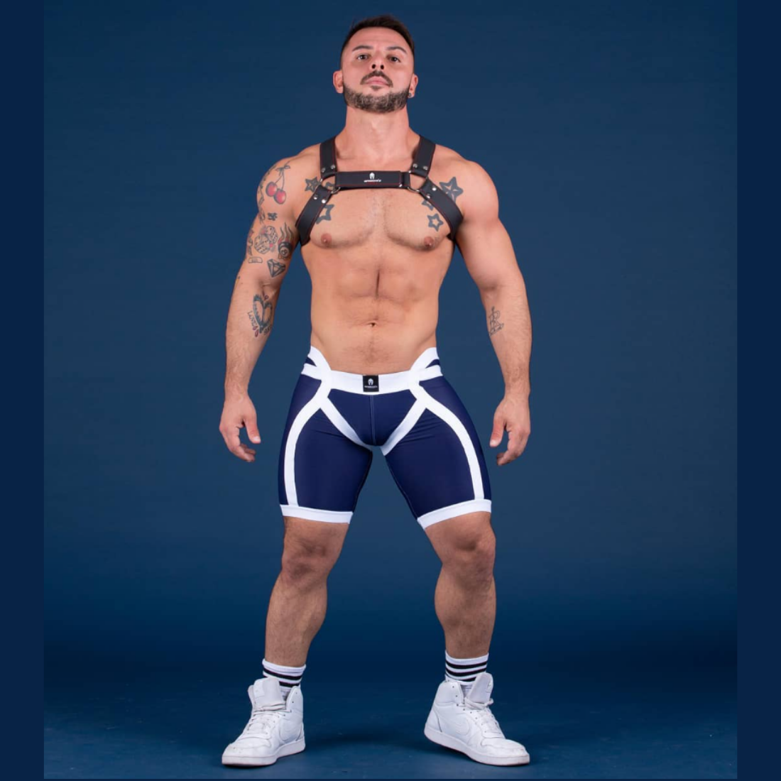 Unieke donkerblauwe short met verlaagde tailleband aan de voorzijde en witte elastische banden, ontworpen door het Italiaanse modehuis Sparta’s Harness en te koop bij Flavourez.