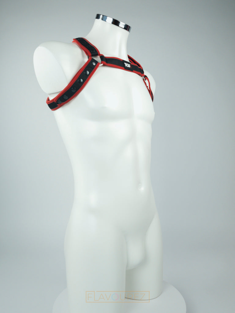 Zwart neopreen harnas met rode reflecterende banden, de perfecte accessoire voor stoute feesten, fetish feesten, gay prides, gay cruises, cruise bars, gay clubs etc. ontworpen door TOF Paris en te koop bij Flavourez.